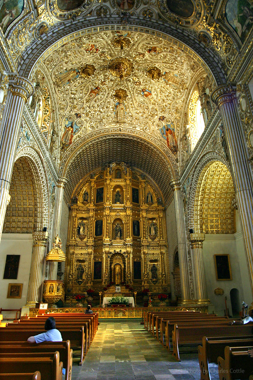 Ornately decorated vaulted ceilings and golden altar of church interior